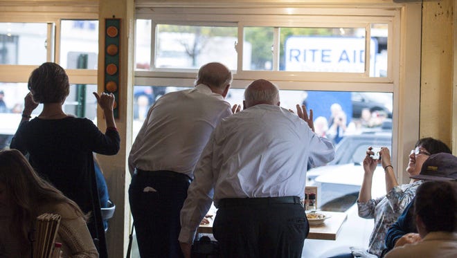 Vice -President Joe Biden, center, waves to the crowd outside the Penny Cluse Cafe in Burlington before participating in a Cancer Moonshot Roundtable at the University of Vermont on Friday, October 21, 2016. With Biden are Democratic gubernatorial candidate Sue Minter, left, and U.S. Senator Patrick Leahy.