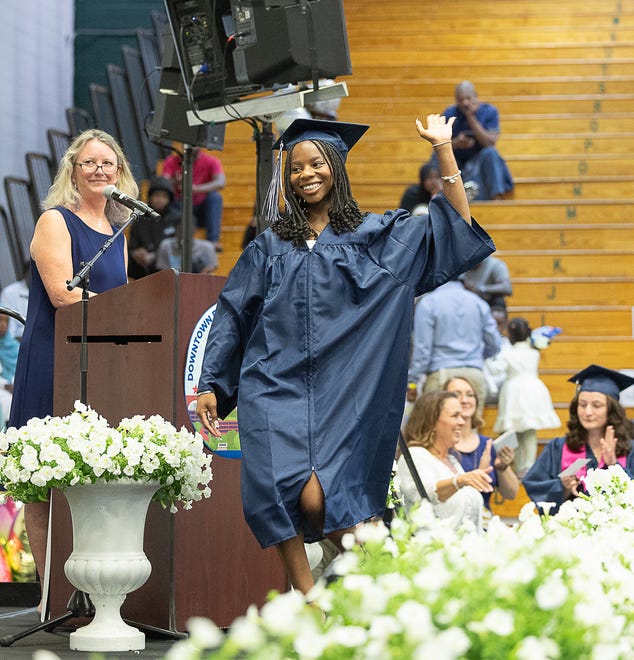 Grace Afwet Victoria Kouadio waves goodbye to her fellow classmates during graduation ceremonies for Burlington High School on Thursday, June 13, 2024, at University of Vermont Patrick Gymnasium in Burlington.