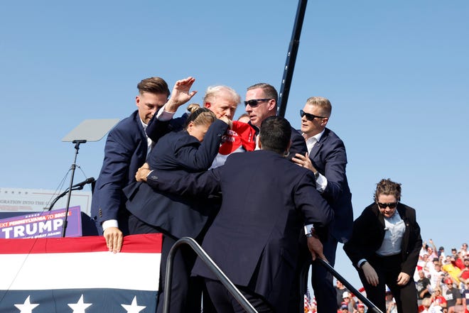 Republican presidential candidate former President Donald Trump is rushed offstage during a rally on July 13, 2024, in Butler, Pennsylvania.