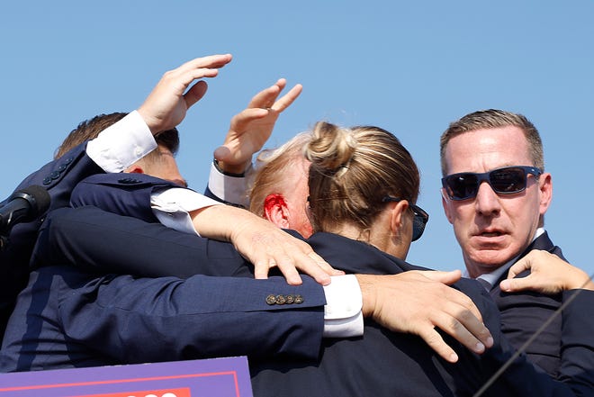 Blood was visible from Trump's ear as the Secret Service still surrounded him to begin to move off the stage.