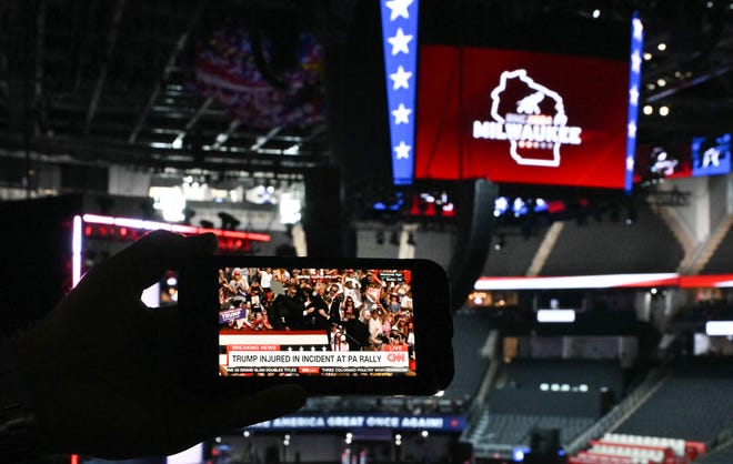 A member of the media watches the news on their phone ahead of the 2024 Republican National Convention in Milwaukee, Wisconsin.