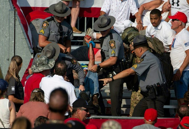 A person is removed by state police from the stands after guns were fired at the Trump campaign event in Butler, Pennsylvania, July 13, 2024.