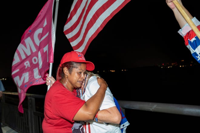 Yammi Santa Cruz hugs Dina Coury after they watched a video of former President Donald Trump being shot in the ear at a campaign rally in Pennsylvania. The supporters gathered across the bridge from Mar-a-Lago on July 13, 2024, in Palm Beach, Florida.