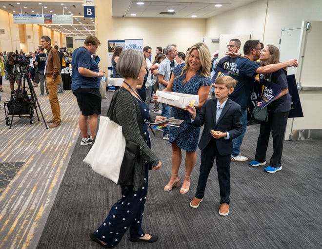 Darcie Goodin and son Berley, 11, hand out cookies to support husband and father Terry Goodin, a candidate for lieutenant governor, Saturday, July 13, 2024, during the Indiana Democratic State Convention in Indianapolis.