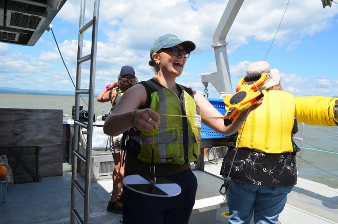 UVM Agroecology Fellow Nora Beer explains the purpose of a Secchi - to measure the clarity of water - aboard the research vessel Marcelle Melosira July 18, 2024.