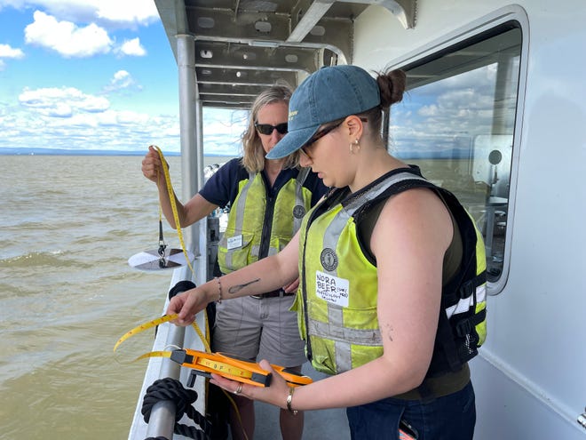 Sea Grant Executive Program Leader Kris Stepenuck and UVM Agroecology Fellow Nora Beer prepare to drop a Secchi disk into Lake Champlain to measure water clarity July 18, 2024.