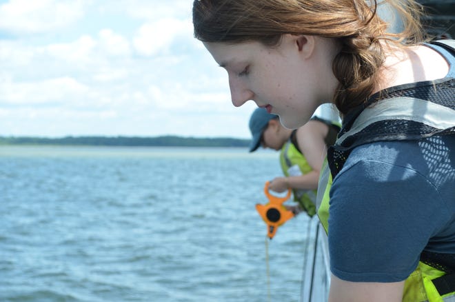 UVM Agroecology Fellows Nora Beer and Anna Hoppe give a demonstration of the Secchi, a water clarity testing device, aboard the Marcelle Melosira July 18, 2024.