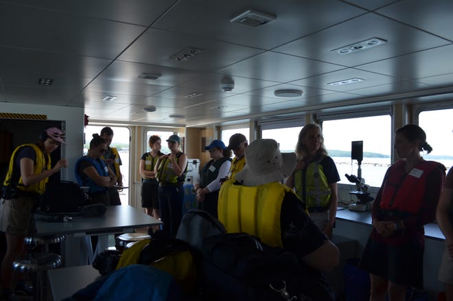 A group of scientists and reporters sit in the classroom aboard the research vessel Marcelle Melosira July 18, 2024. Media teams were invited for an information boat ride about the work that's done on the craft.