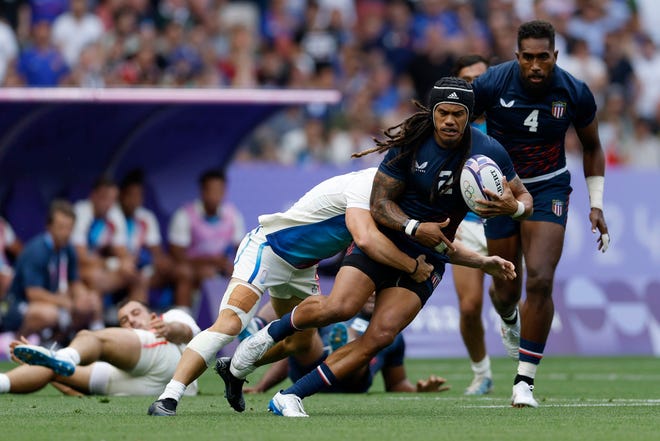 Team United States back Maka Unufe (2) runs the ball against France in a rugby Group C match during the Paris 2024 Olympic Summer Games at Stade de France on July 24, 2024.