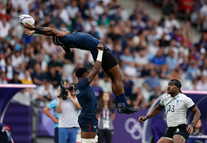 Team United States back Kevon Williams (6) is lifted up by Team United States forward Aaron Cummings (1) against Fiji in a rugby Group C match during the Paris 2024 Olympic Summer Games at Stade de France on July 24, 2024, in Paris Saint-Denis, France.