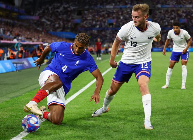 Loic Bade of France was in action with Duncan McGuire of the United States during a men's Group A football match during the Paris 2024 Olympic Summer Games at Orange Velodrome on July 24, 2024 in Marseille, France.