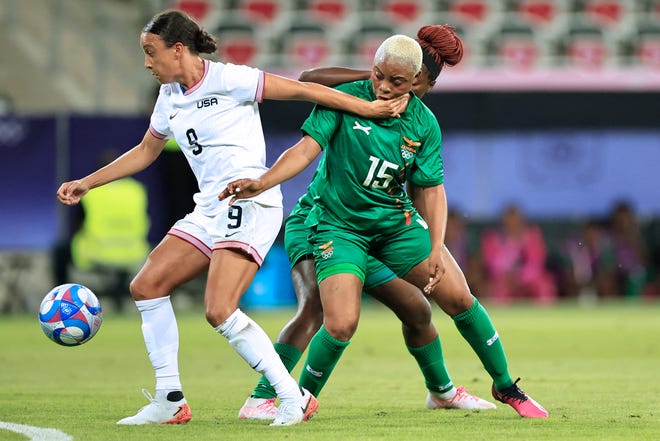 US forward #09 Mallory Swanson and Zambia's forward #15 Hellen Chanda vie for the ball in the women's group A football match between the USA and Zambia during the Paris 2024 Olympic Games at the Nice Stadium in Nice, on July 25, 2024. (Photo by Valery HACHE / AFP) (Photo by VALERY HACHE/AFP via Getty Images)