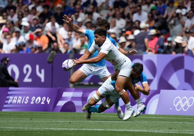 Team United States back Naima Fuala'Au (7) passes the ball away from Team Uruguay forward James McCubbin (1) during the Paris 2024 Olympic Summer Games at Stade de France.