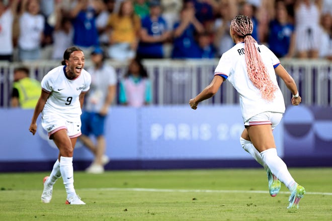 US forward #05 Trinity Rodman (R) celebrates scoring the opening goal in the women's group A football match between the USA and Zambia during the Paris 2024 Olympic Games at the Nice Stadium in Nice, on July 25, 2024.