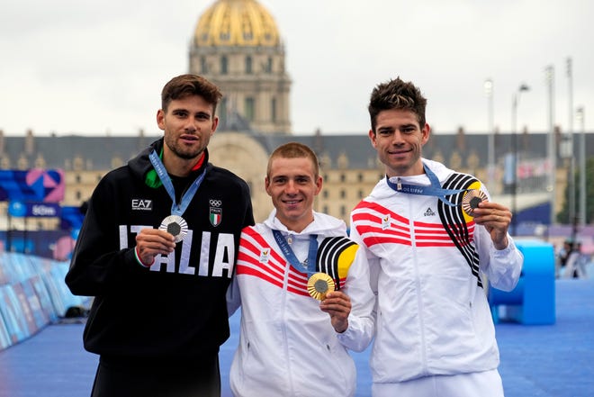 Filippo Ganna (ITA) celebrates winning the silver medal, Remco Evenepoel (BEL) celebrates winning the gold medal and Wout van Aert (BEL) celebrates winning the bronze medal in the men’s individual time trial road cycling during the Paris 2024 Olympic Summer Games at Grand Palais-Pont Alexandre III.