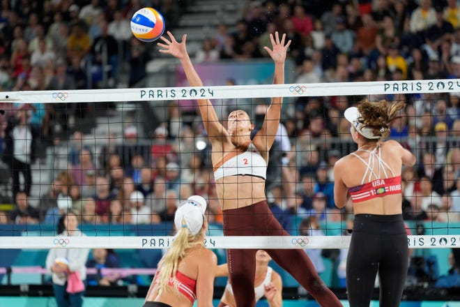 Sophie Bukovec (CAN) tries to block a shot by Kristen Nuss (USA) in a beach volleyball preliminary phase match during the Paris 2024 Olympic Summer Games at Eiffel Tower Stadium.