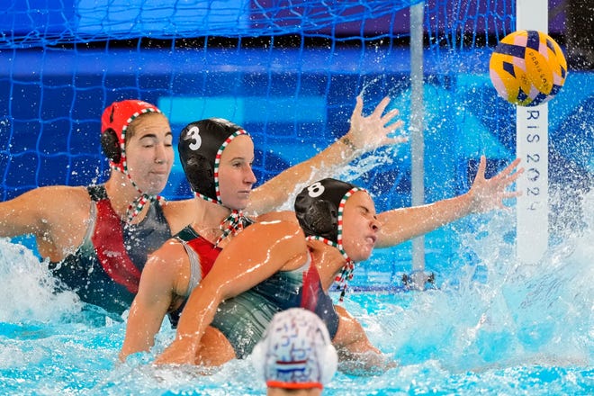 Netherlands goalkeeper Laura Aarts (1), left wing Vanda Valyi (3) and driver Rita Keszthelyi (8) protect their goal against the Netherlands in the women’s water polo group A play during the Paris 2024 Olympic Summer Games at Aquatics Centre.