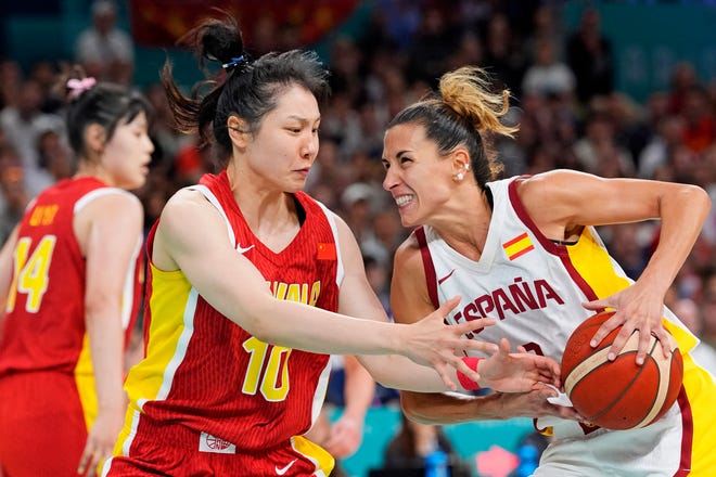 Spain small forward Queralt Casas (9) drives to the basket against People's Republic of China forward Ru Zhang (10) in womenÕs basketball group A play during the Paris 2024 Olympic Summer Games at Stade Pierre-Mauroy.