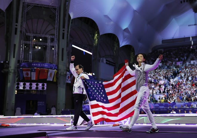 Lee Kiefer (USA) celebrates with coach Amgad Khazbak after winning the women's foil gold medal bout during the Paris 2024 Olympic Summer Games at Grand Palais.